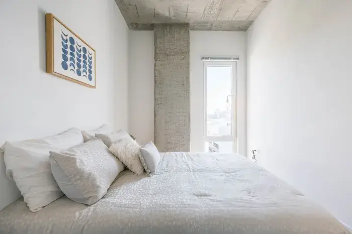 Modern bedroom featuring a queen-sized bed with decorative pillows at Post Chicago Apartments, Lincoln Park furnished apartments.